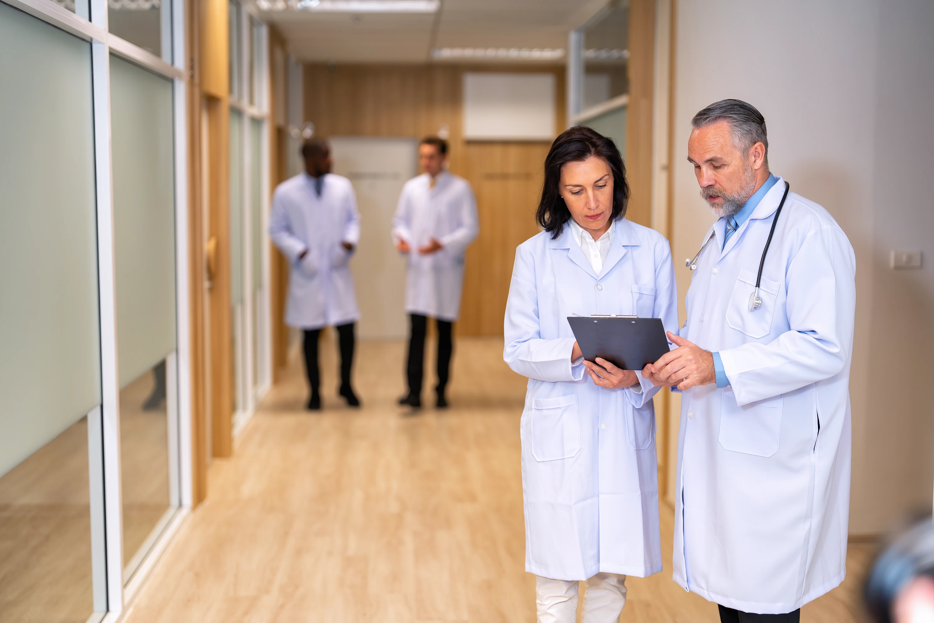 Physicians walking through hospital hallway consulting on clinical decisions