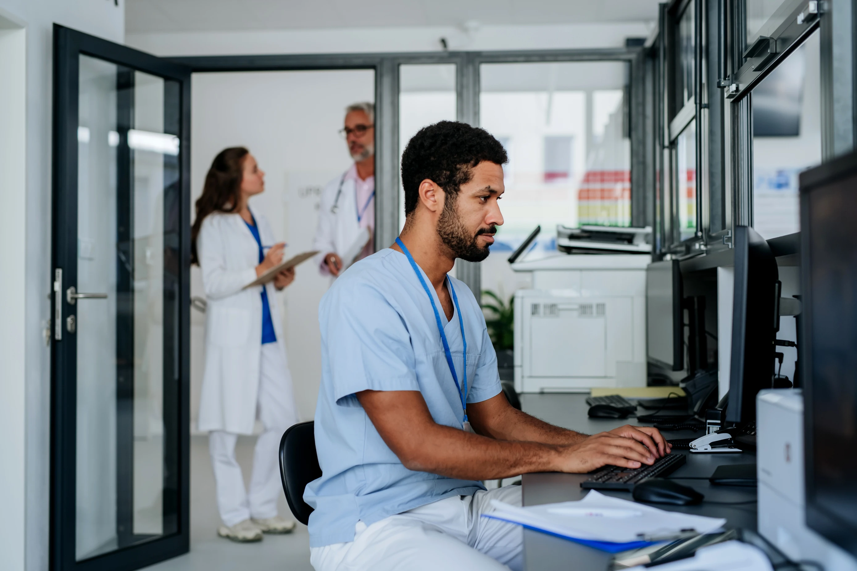 Doctor working on computer reviewing patient data in office
