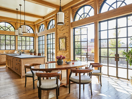 A kitchen with a table, chairs, and windows.