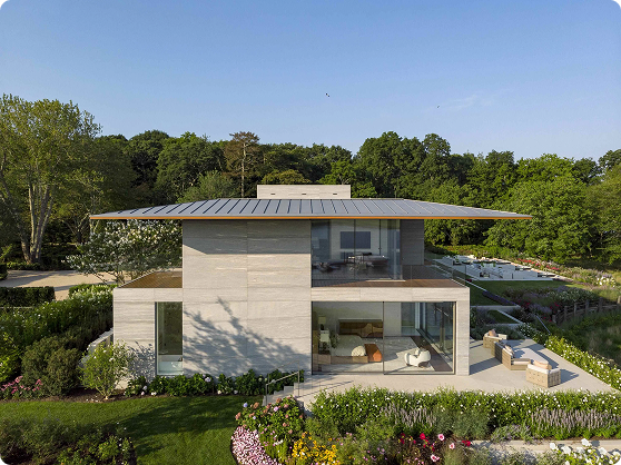 An aerial view of a modern house in the woods.