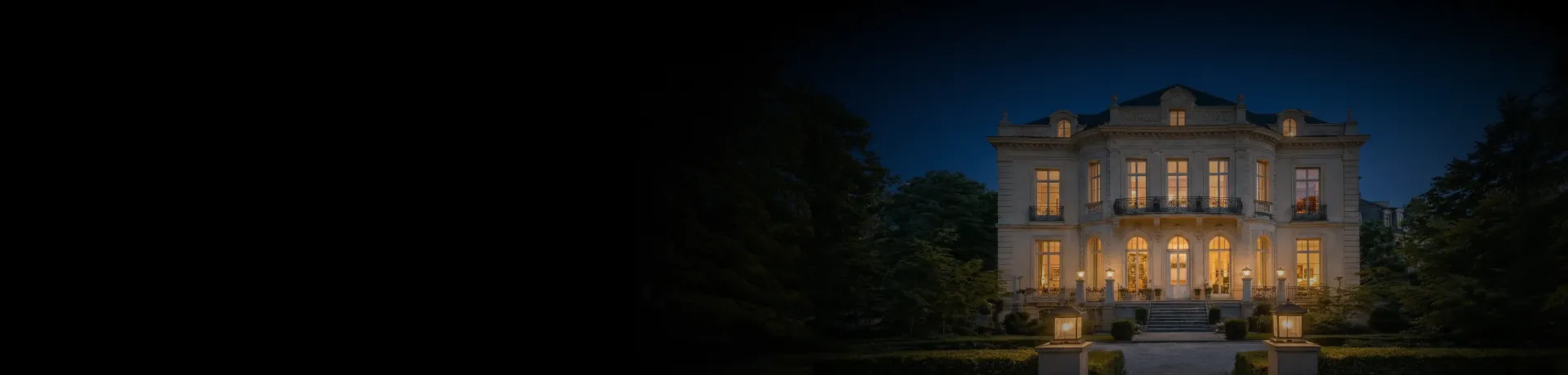 A large house lit up at night in the dark.