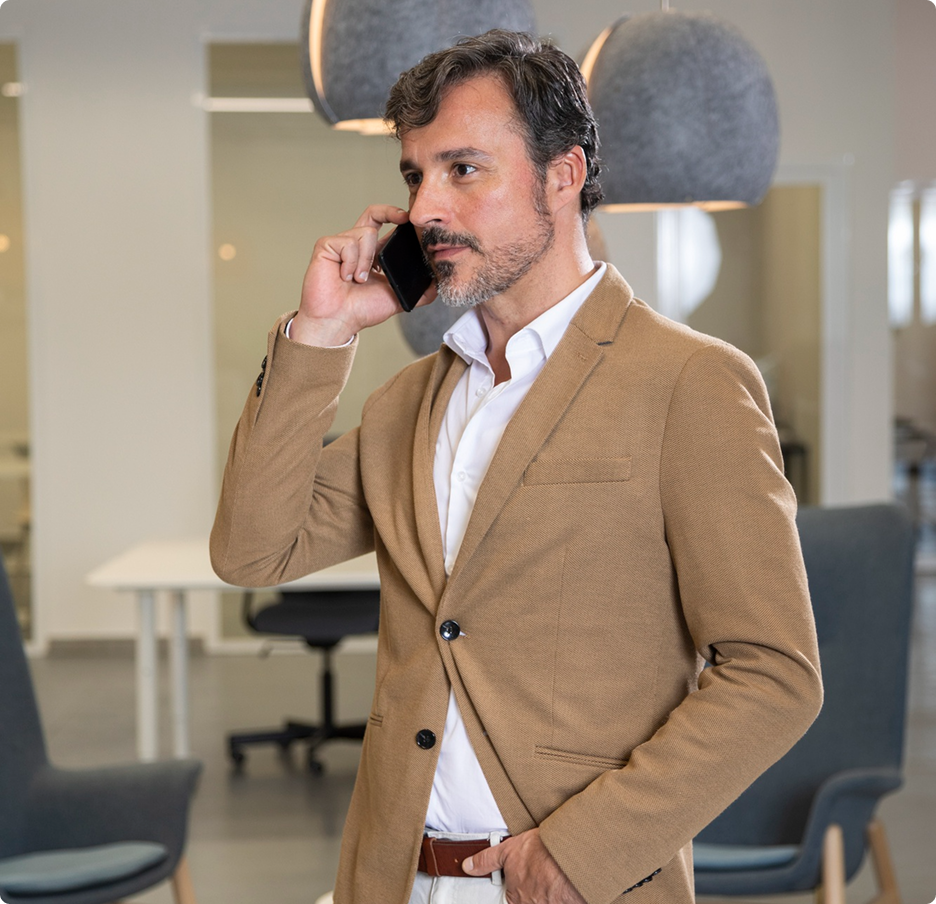 A man in a suit talking on a cell phone.