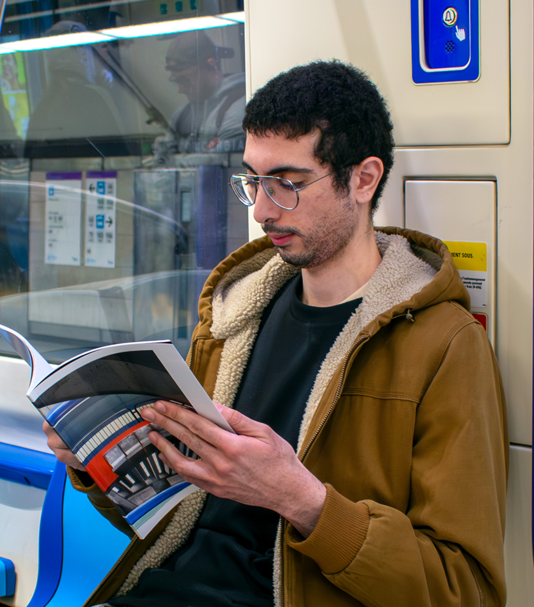 A photo of a person reading the book while commuting