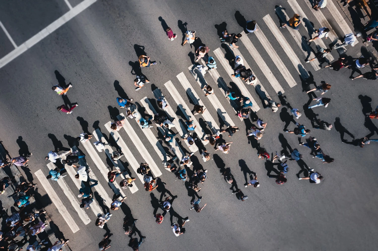 Overhead view of people crossing busy city intersection