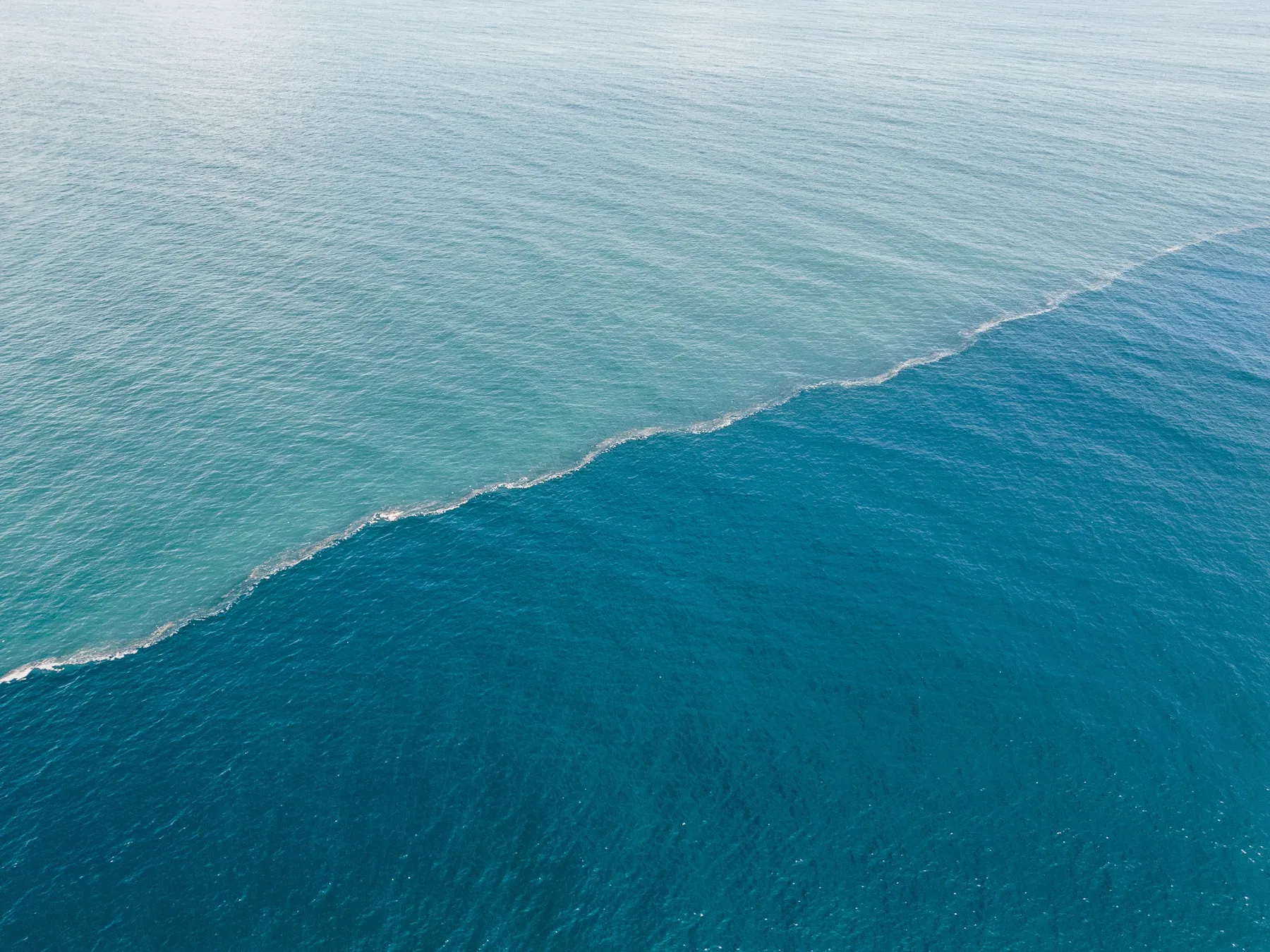 Aerial view of ocean water showing the meeting of two water masses