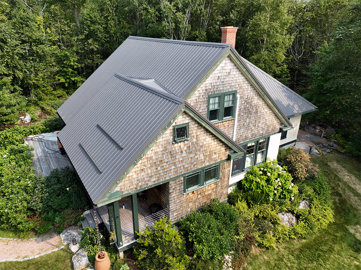 Screw-down metal roof panels with visible fasteners on a completed installation.