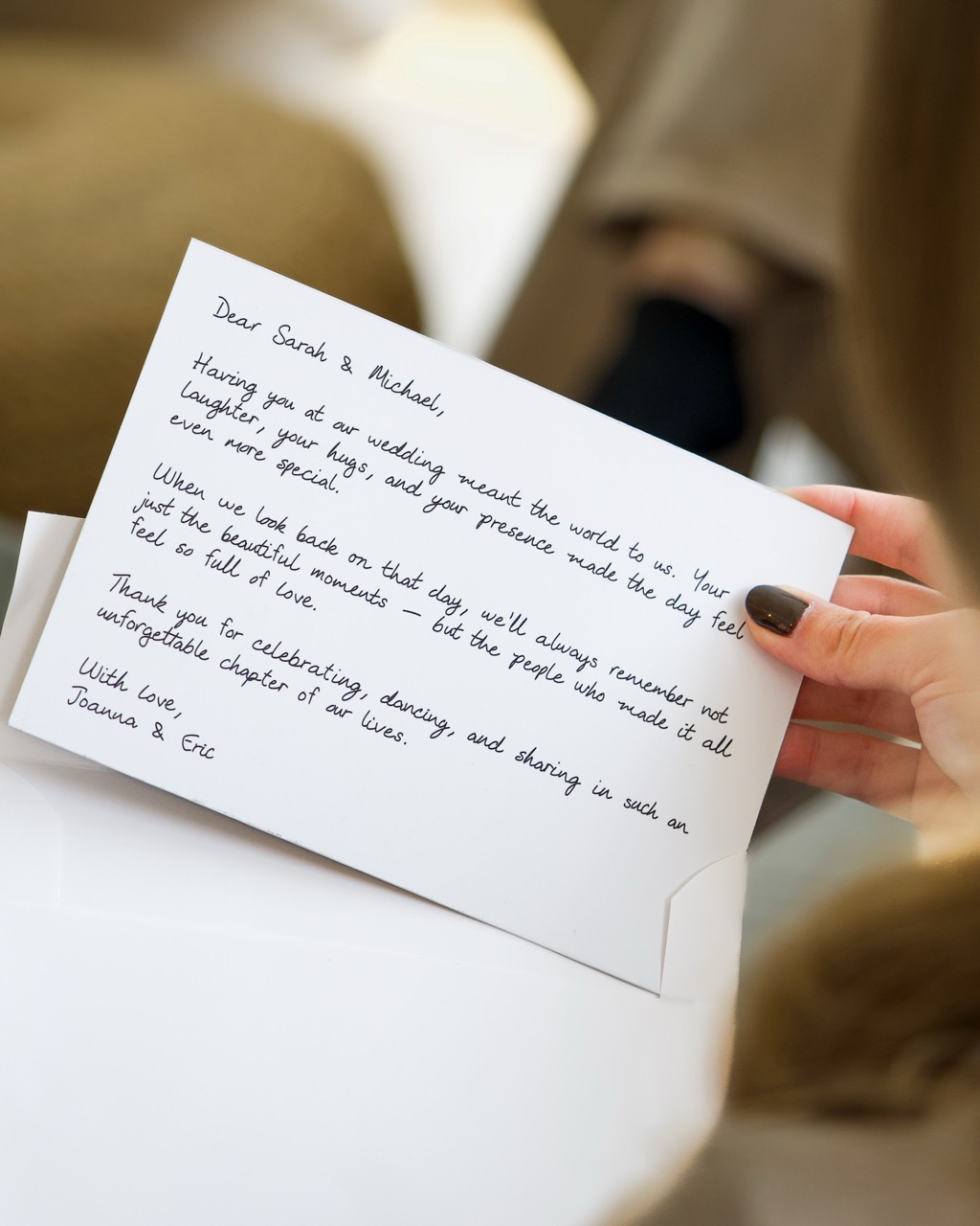 Handwritten thank you card held in hands