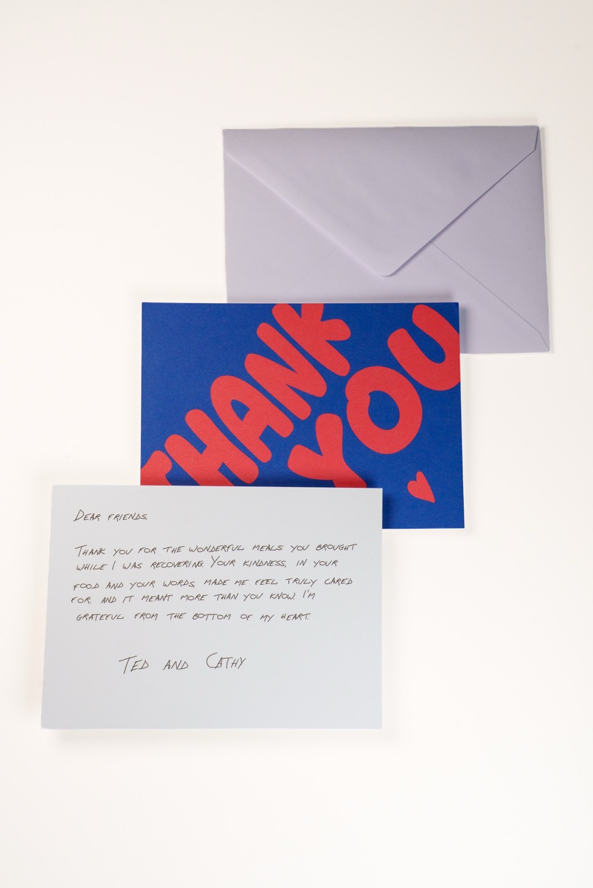 Smiling woman reading a flat photo thank you card
