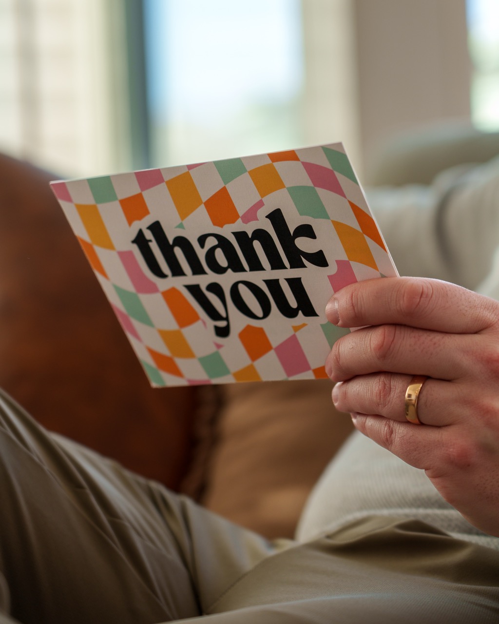 Recipient reading a handwritten card on a couch