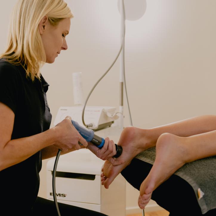 Provider applying radial shockwave therapy to a patient’s heel for plantar fasciitis.