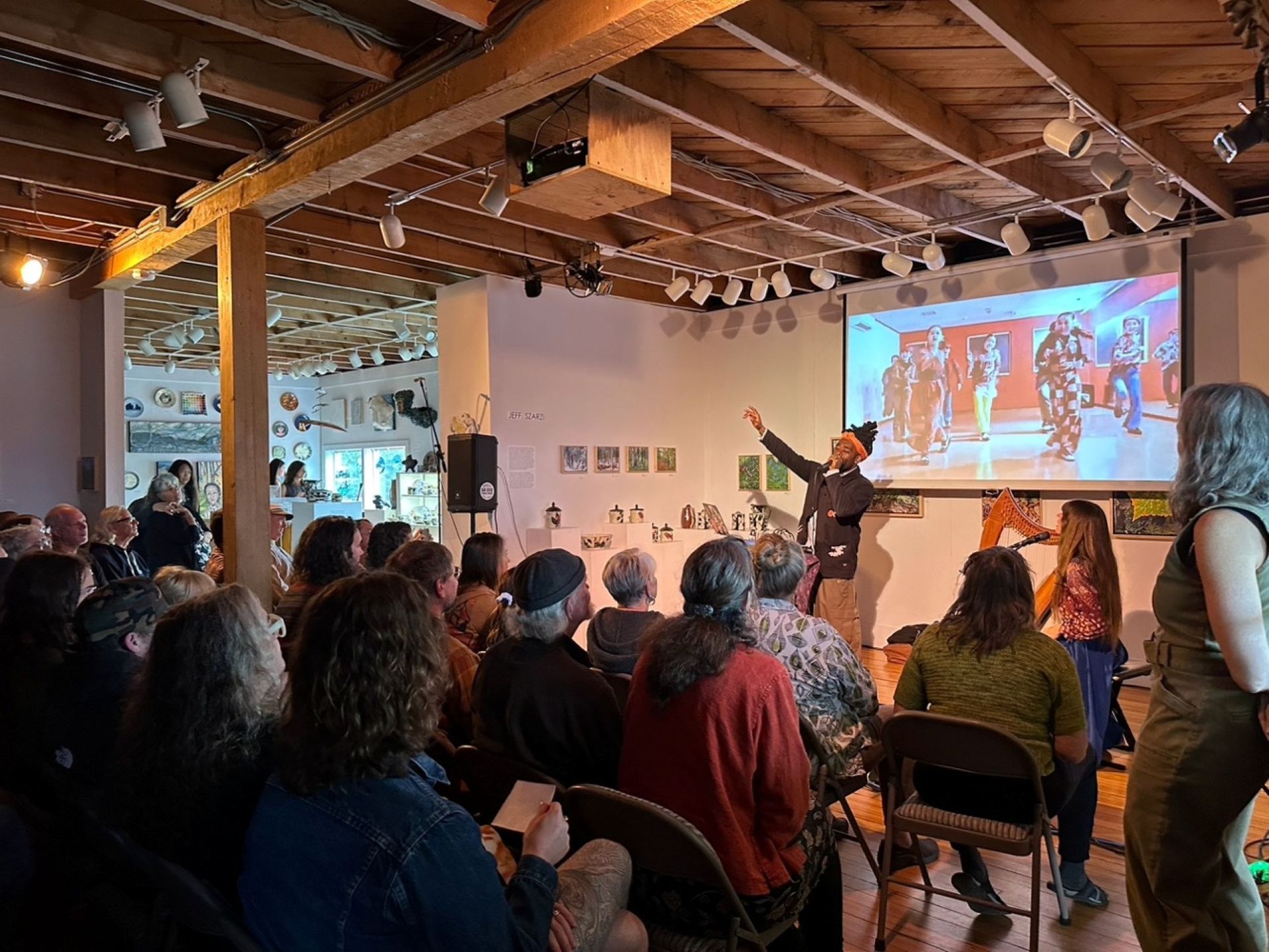 image of a community music event with a singer and a harp player