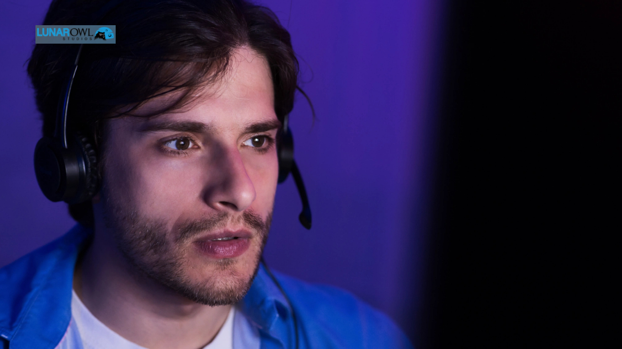 A man wearing headphones smiles while looking directly at the camera.