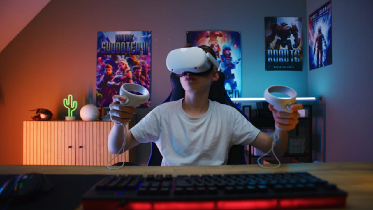 A young boy in a virtual reality headset, grasping two cups, representing the concept of expanding audience reach.