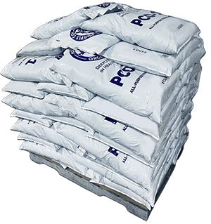 Stacked white bags labeled PCO on a wooden pallet against a white background.