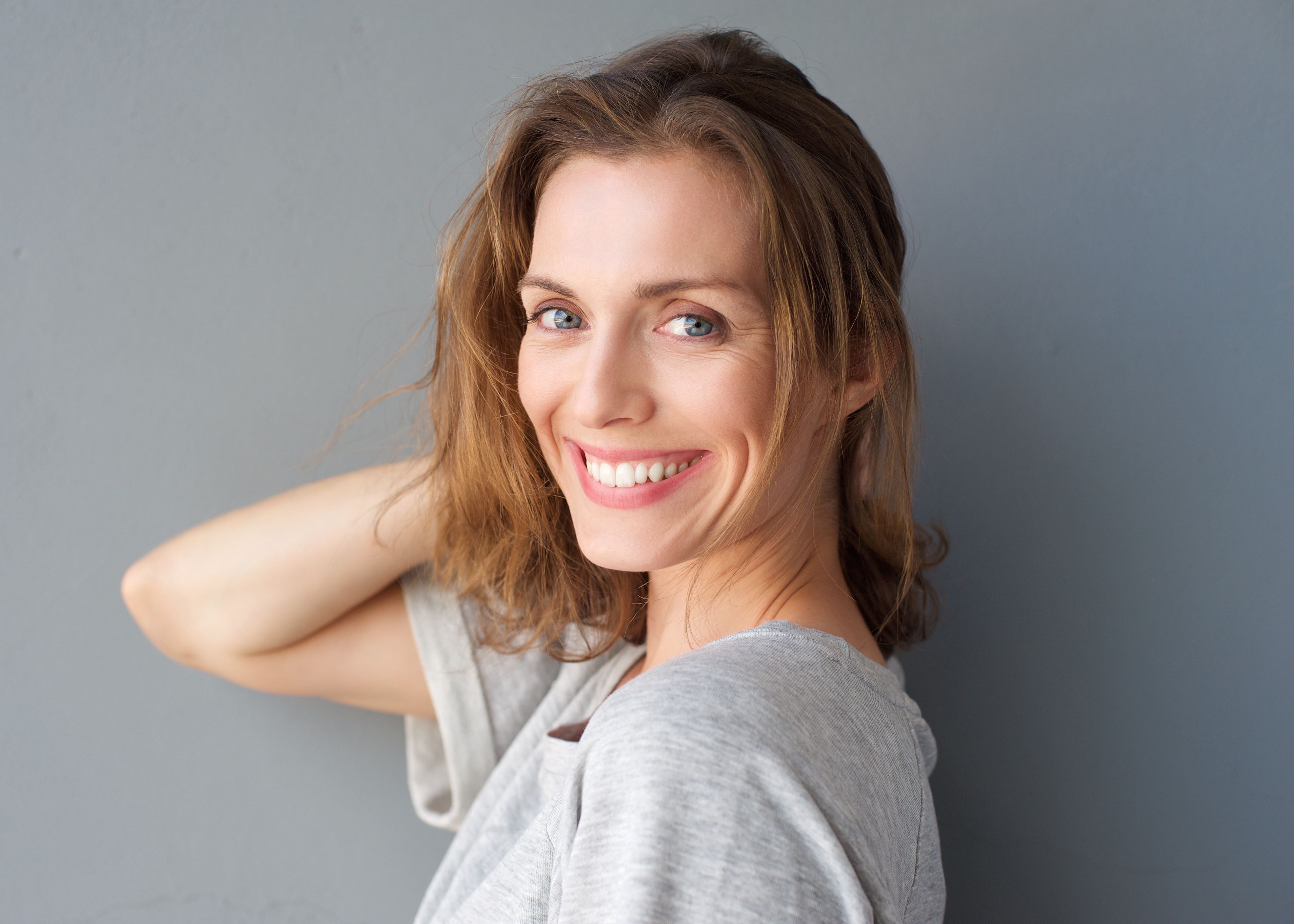 woman touching hair gray background