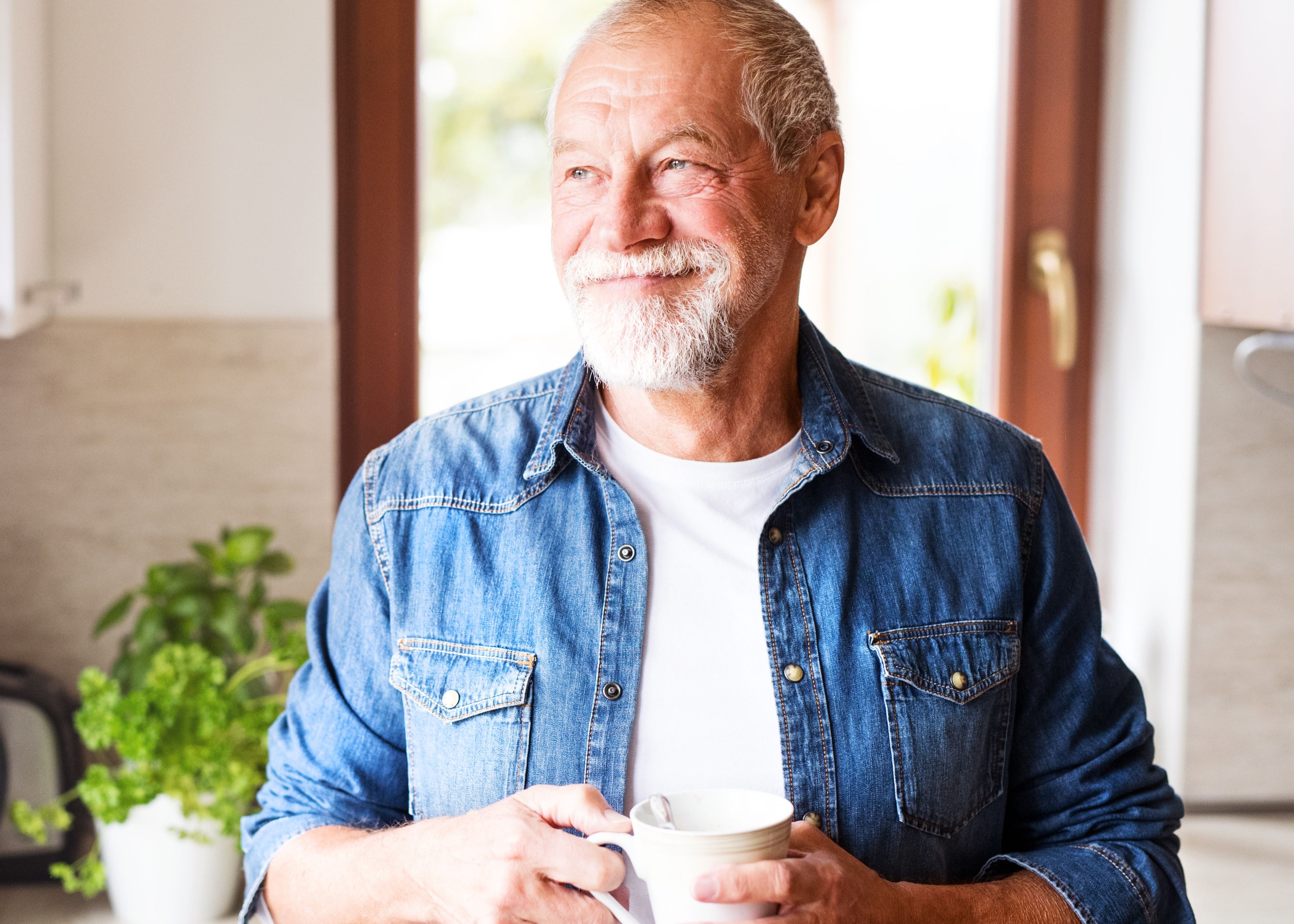 mature man smiling holding cup 