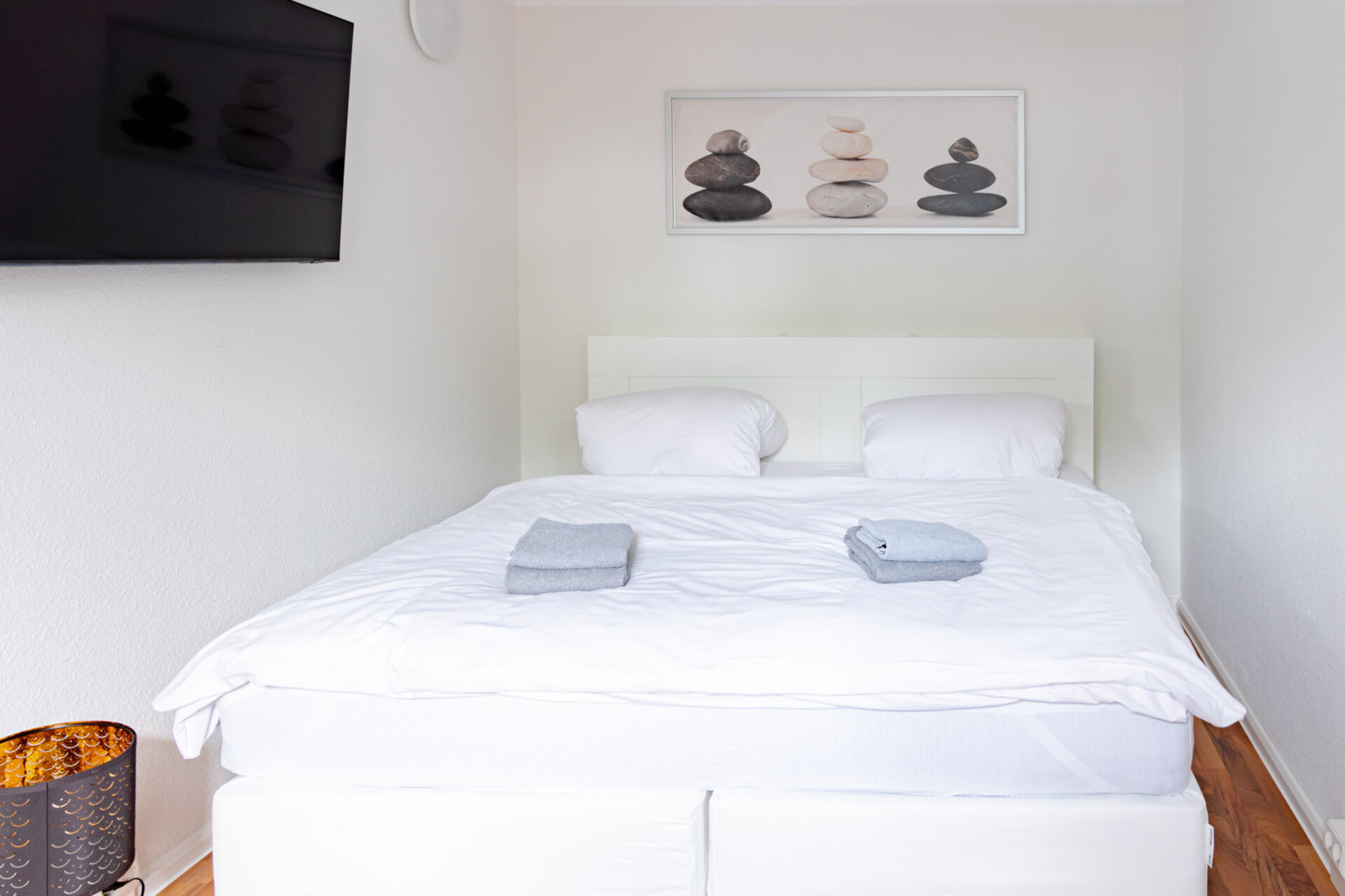 Doppelbett im Schlafzimmer mit Bild im Hintergrund