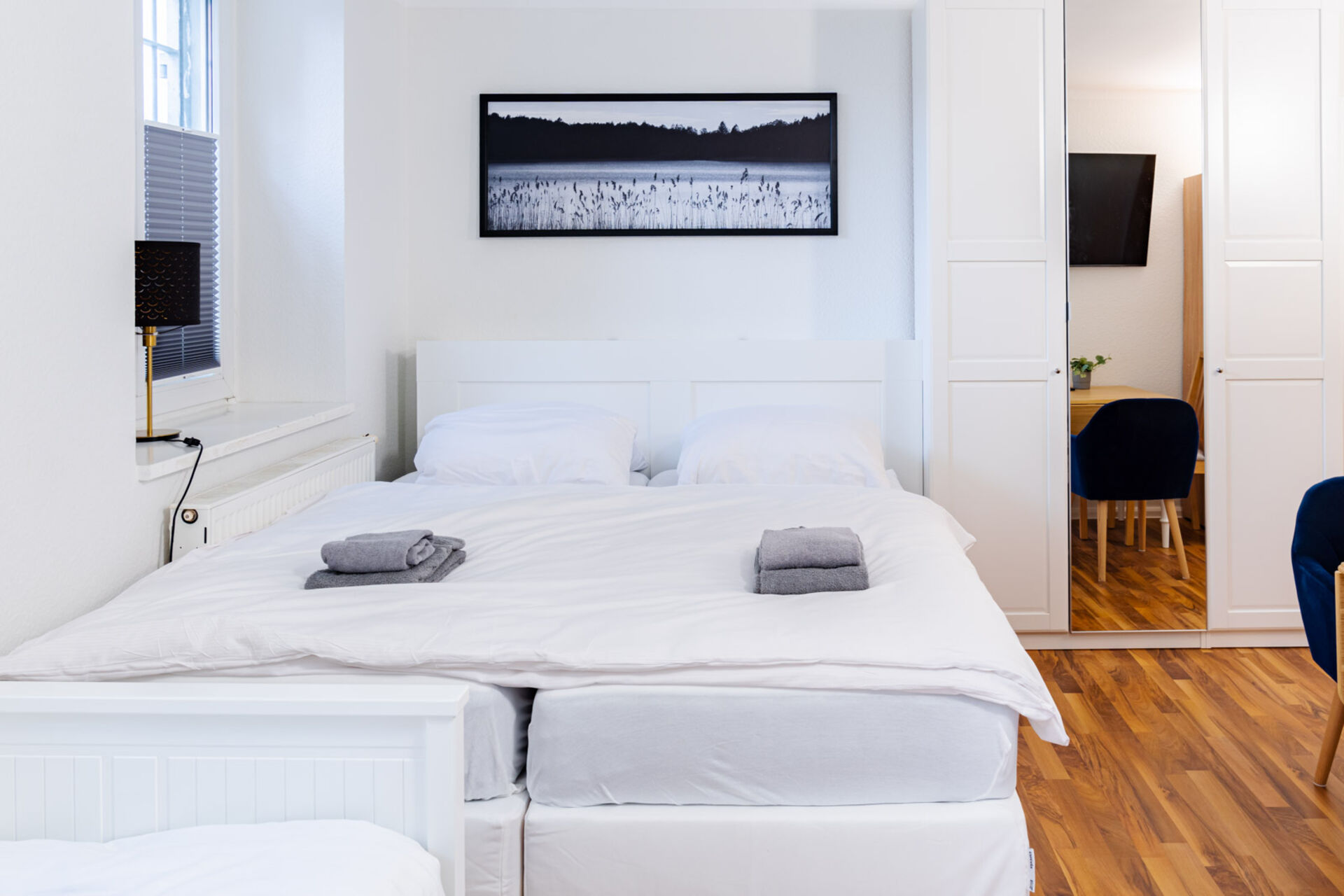 Doppelbett mit Bild im Hintergrund