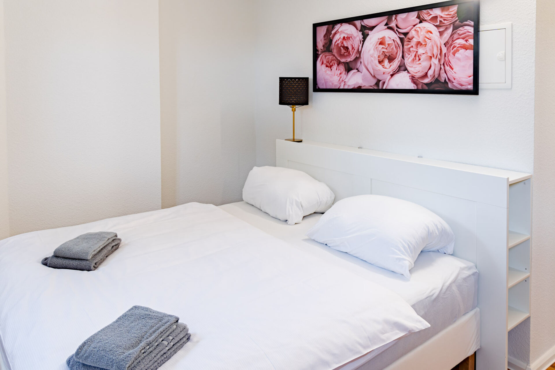 Doppelbett mit Bild im Hintergrund