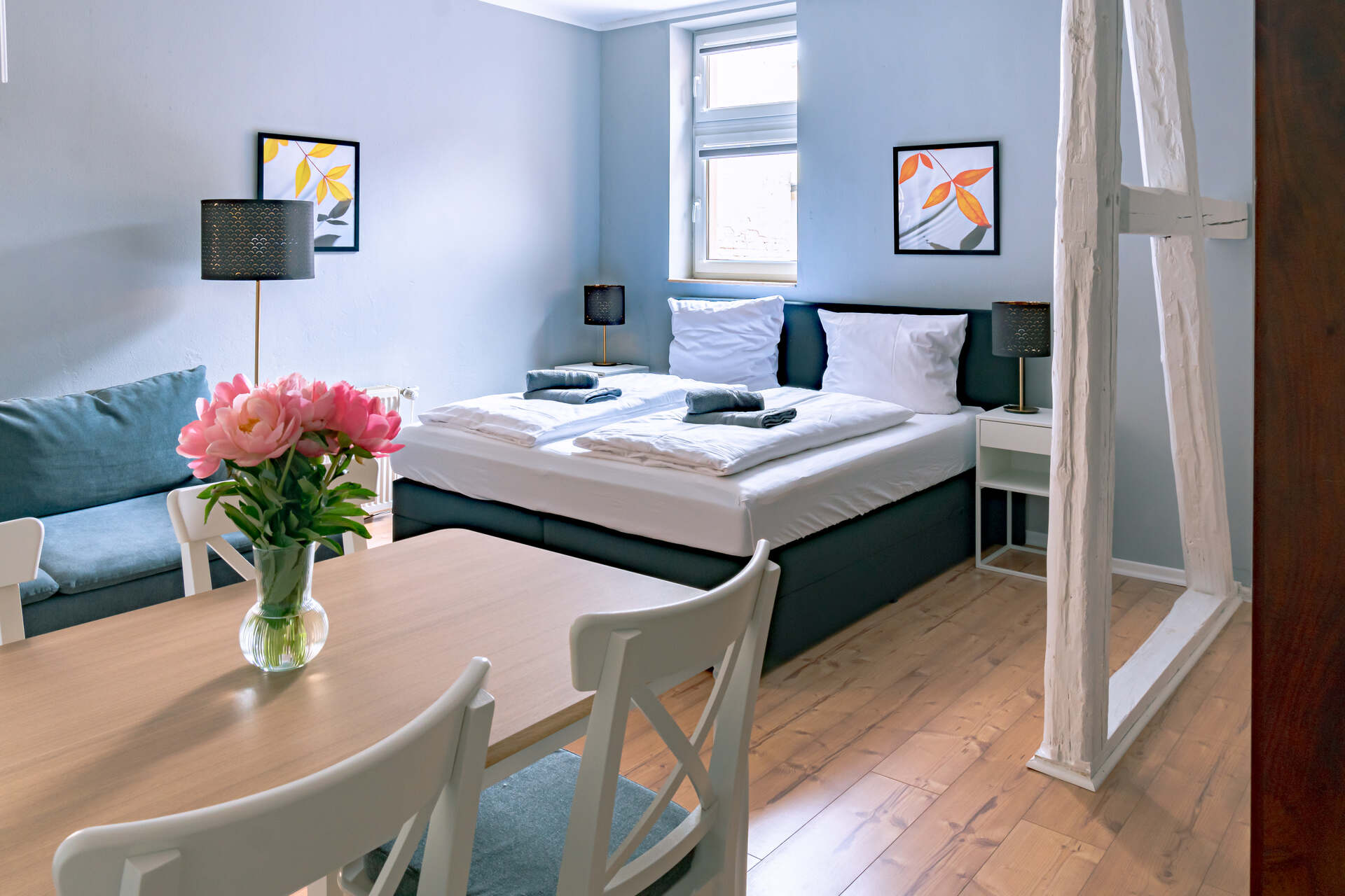 Doppelbett mit Blumen im Vordergrund