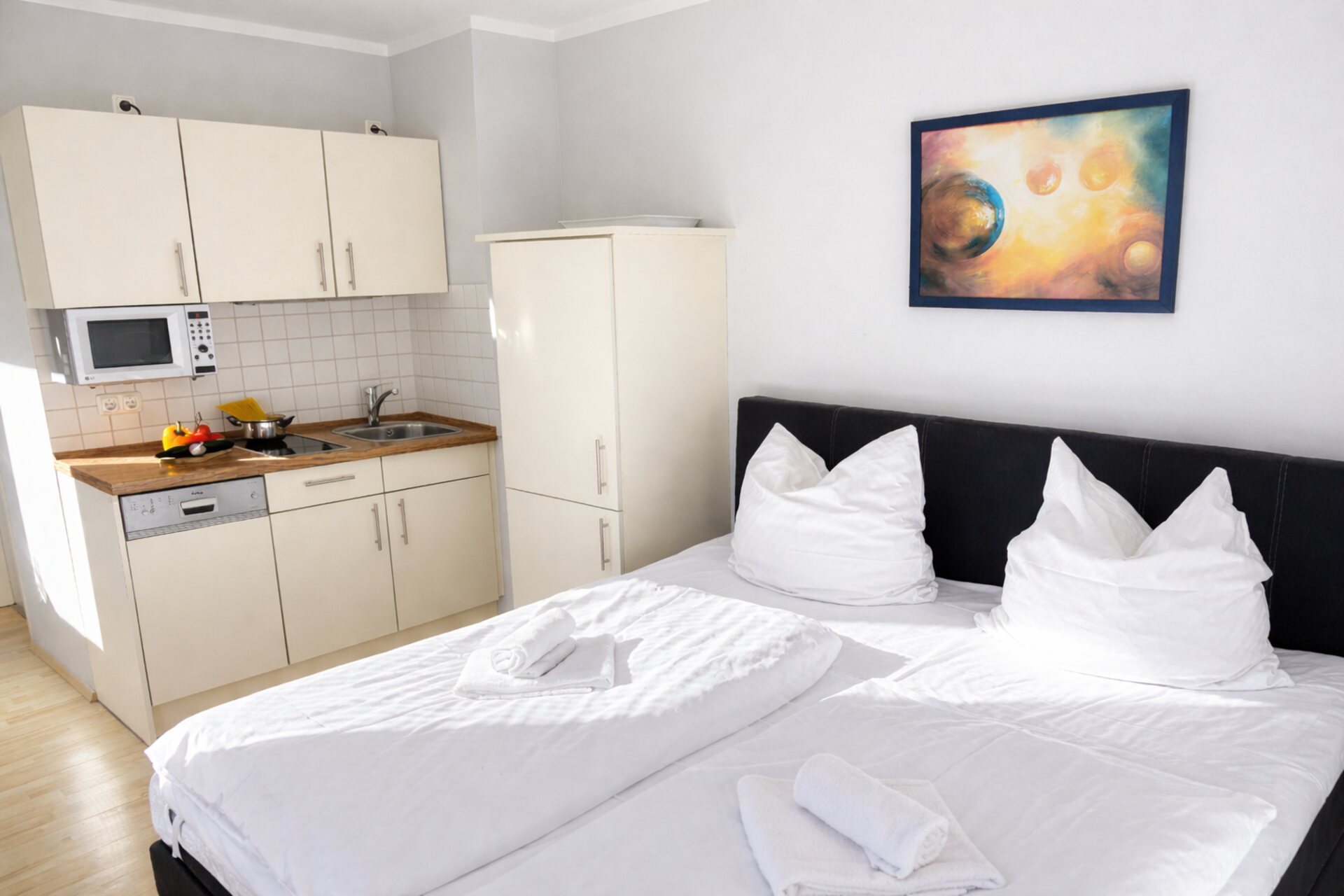 Doppelbett mit Kueche im Hintergrund