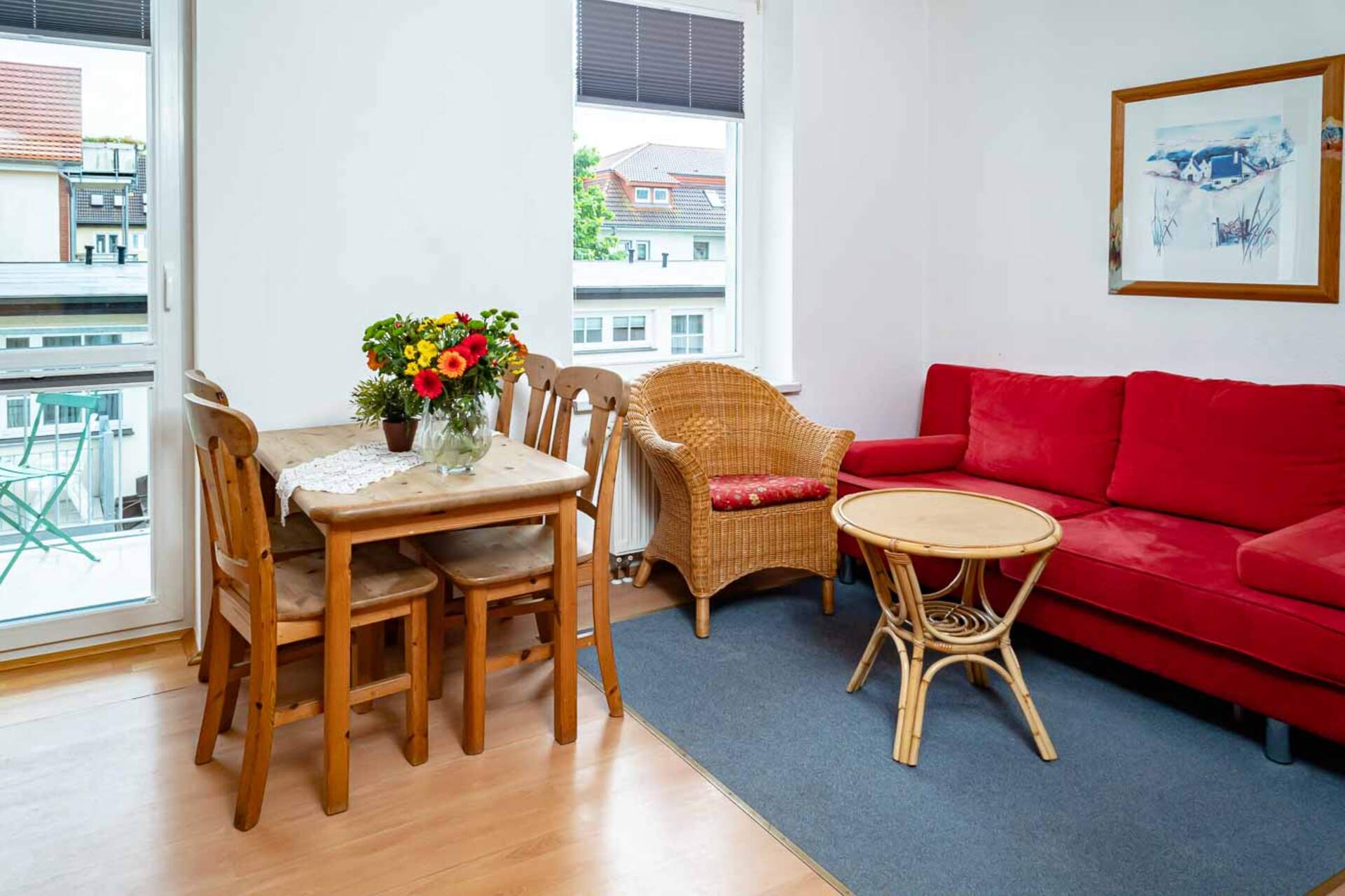 Wohnzimmer mit Couch und Essbereich und Blick auf den Balkon