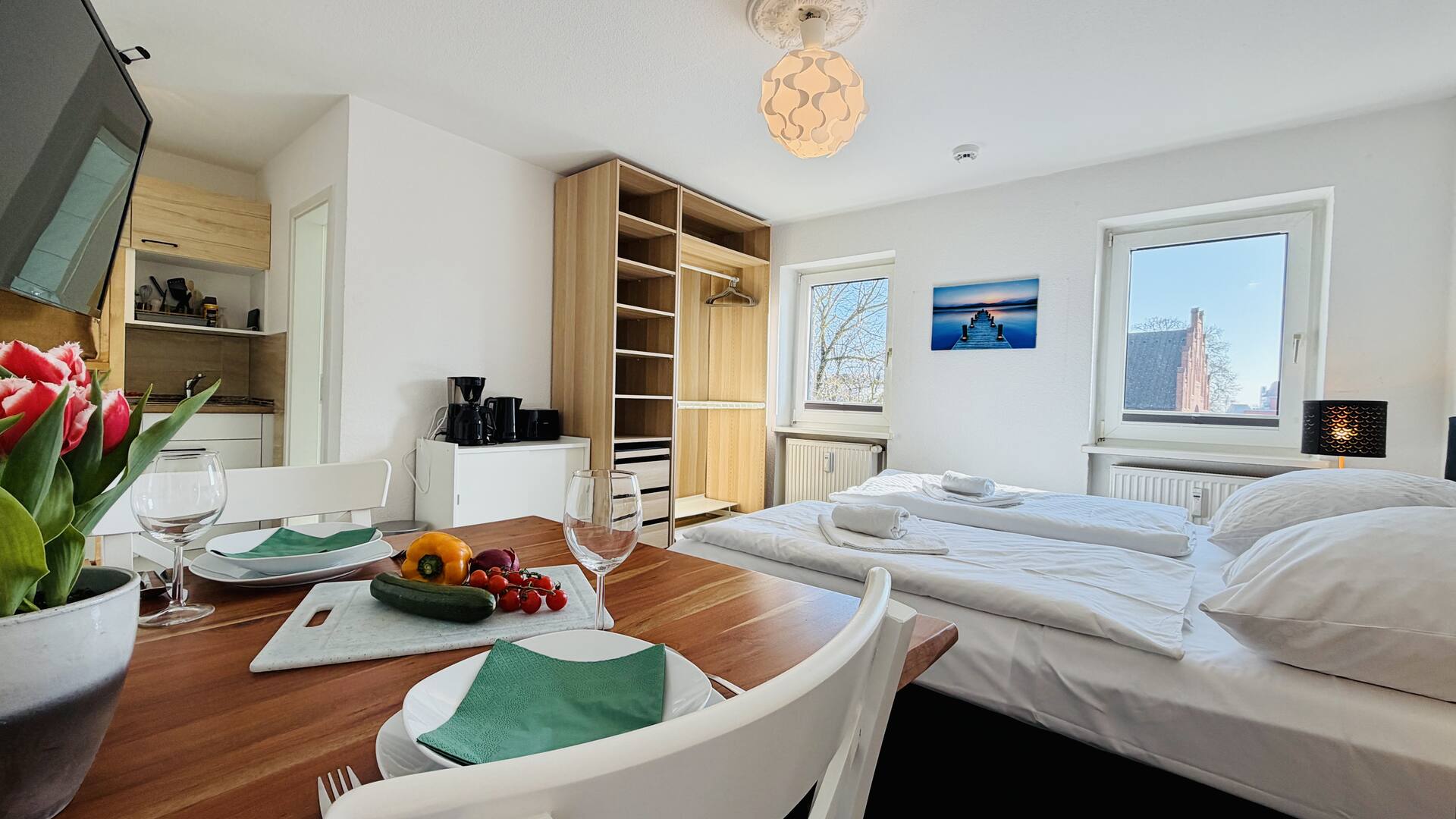 Gedeckter Esstisch mit Bett und Kirchenplatz im Hintergrund