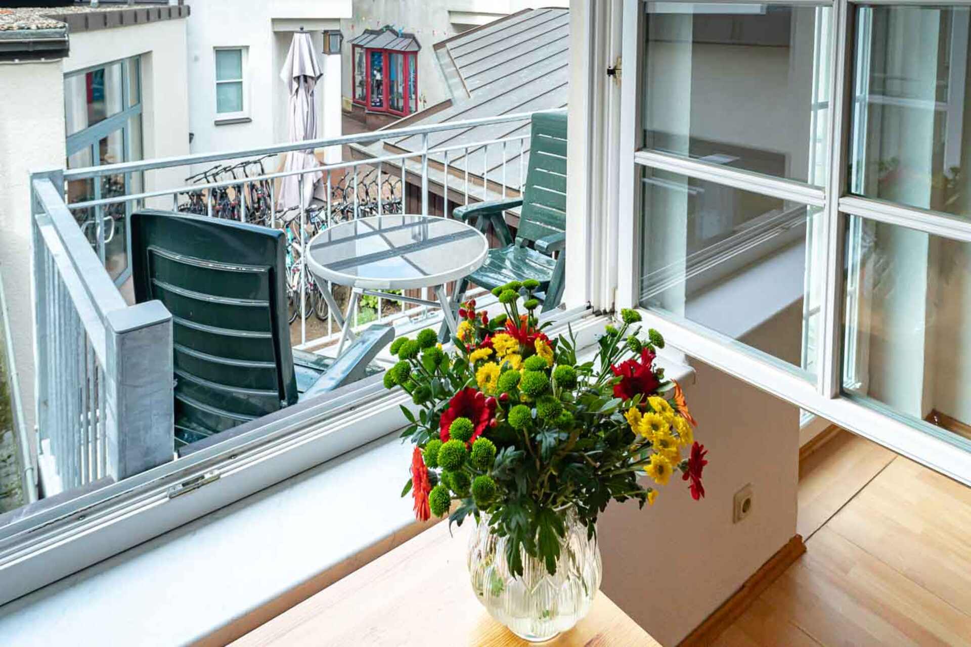 Blumen auf dem Tisch mit dem Balkon im Hintergrund