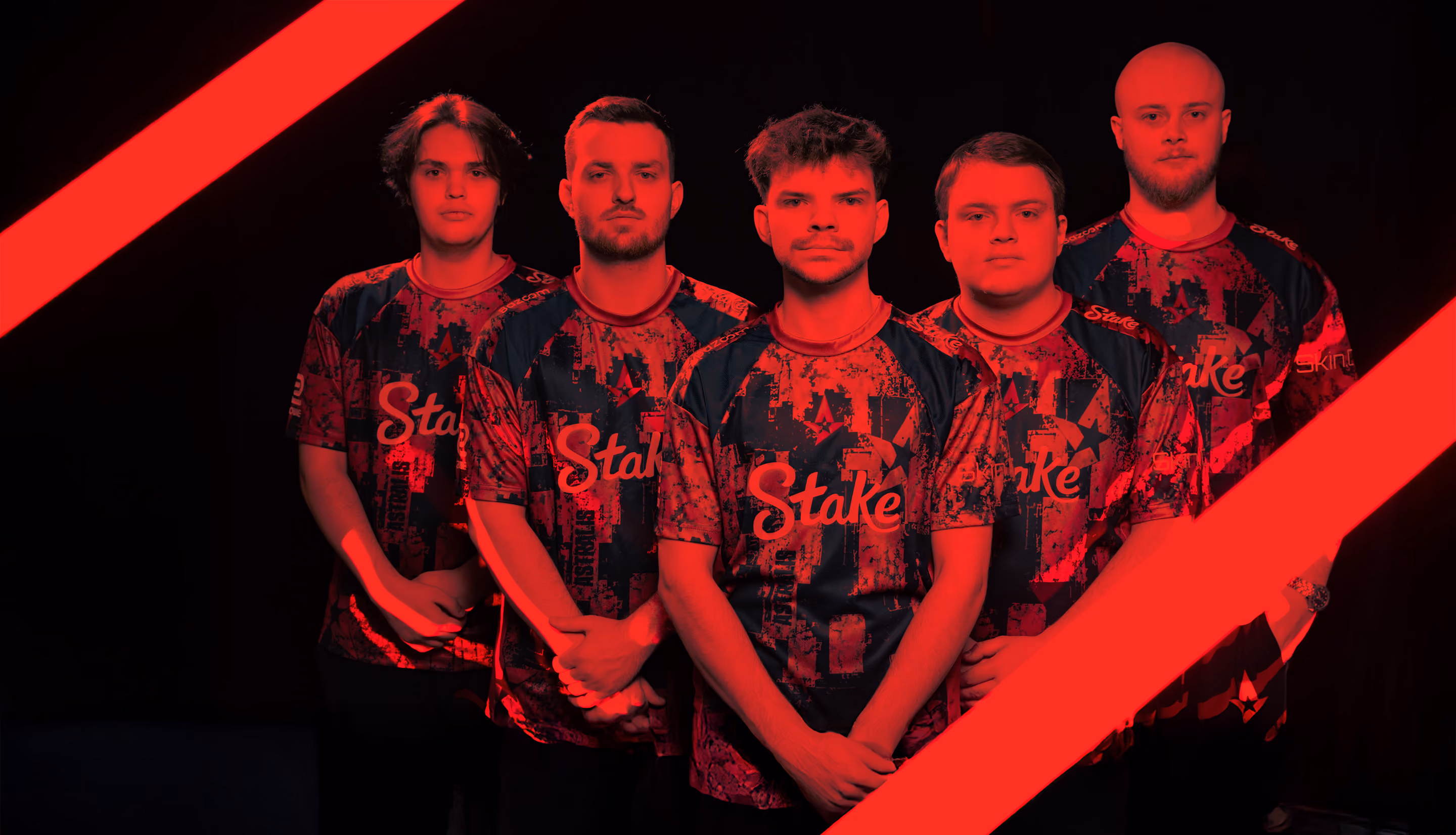 Five Astralis team members in team jerseys against a dark background with a red overlay.