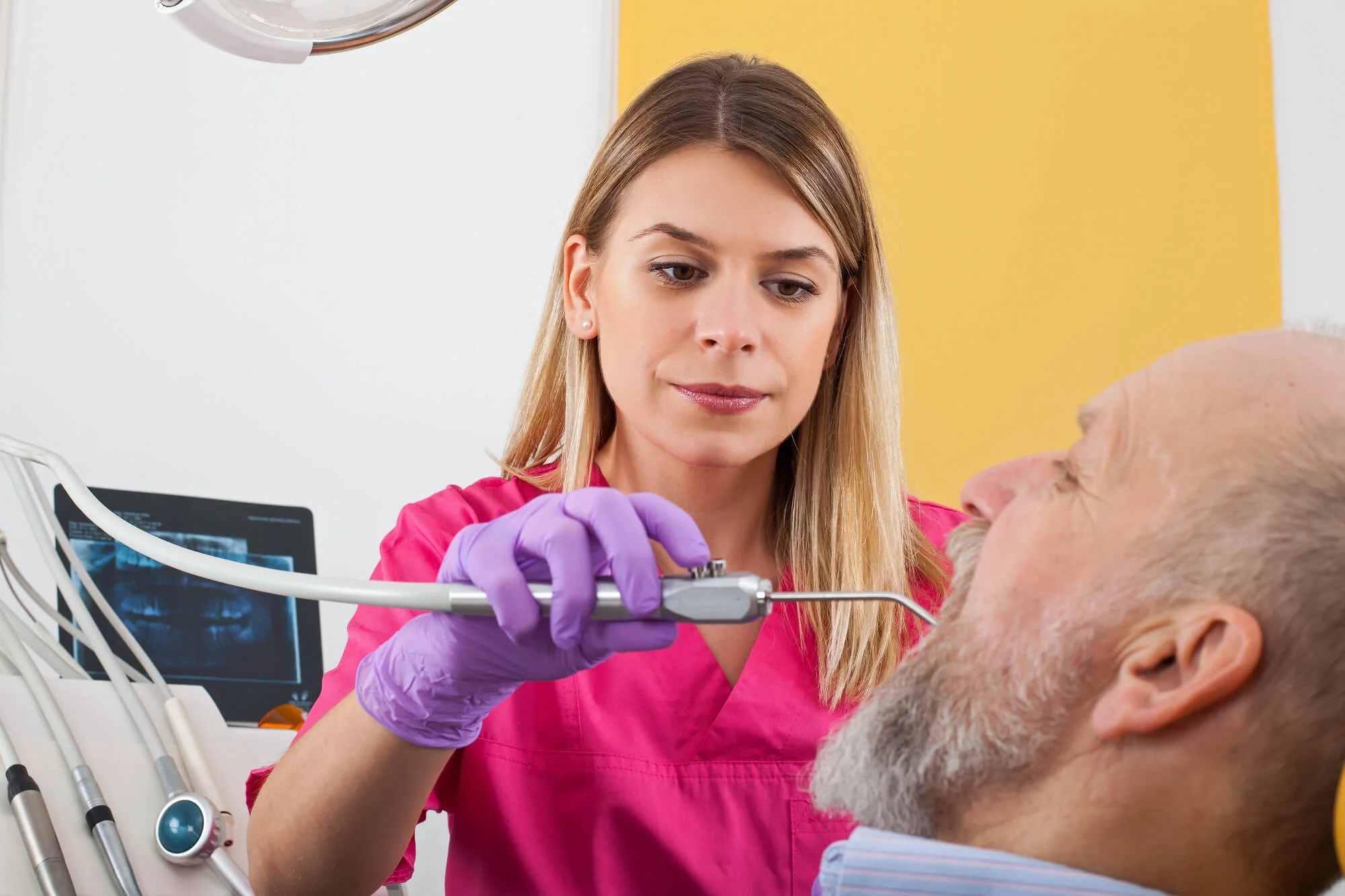 Dentist examining an older patient during a checkup