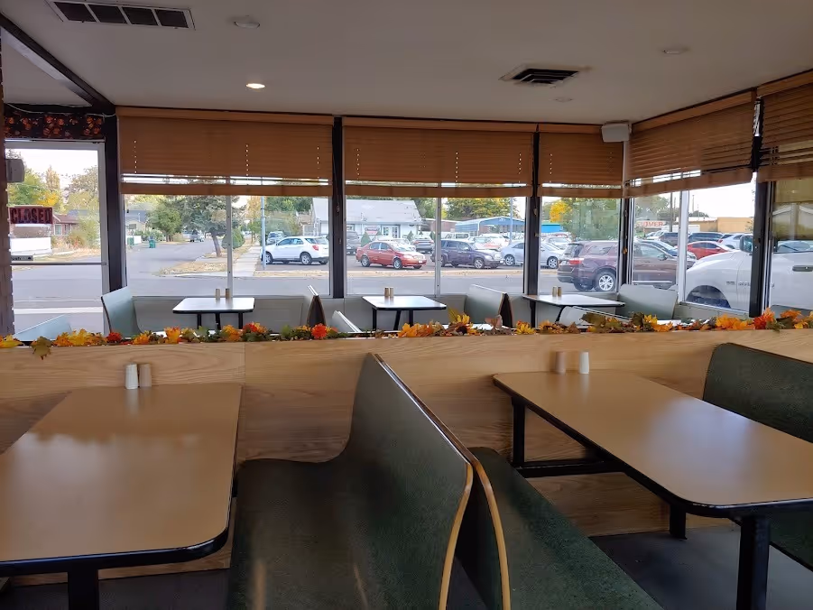 A restaurant with a wooden table and chairs.