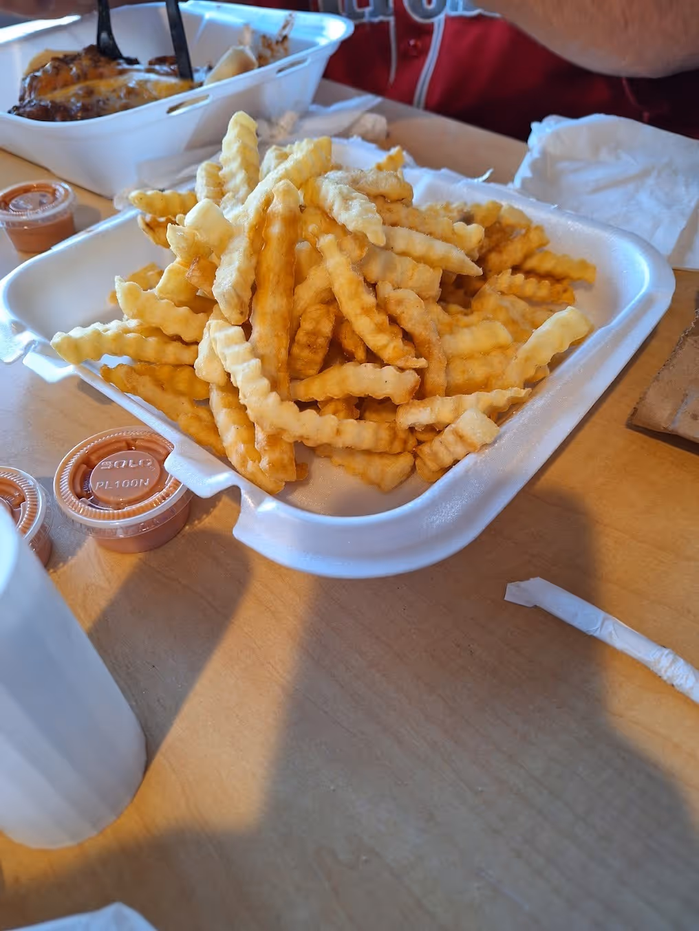 A white styrofoam container filled with french fries.
