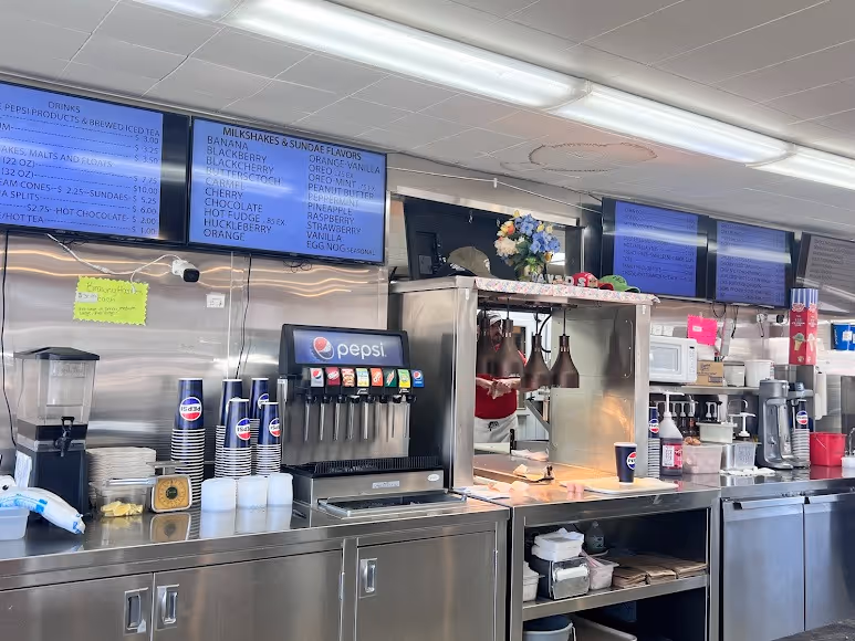 A woman is standing in front of a soda machine.