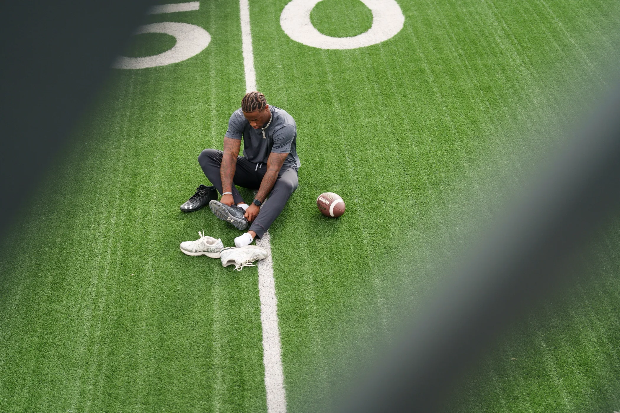 Athlete lacing his cleats on a football field
