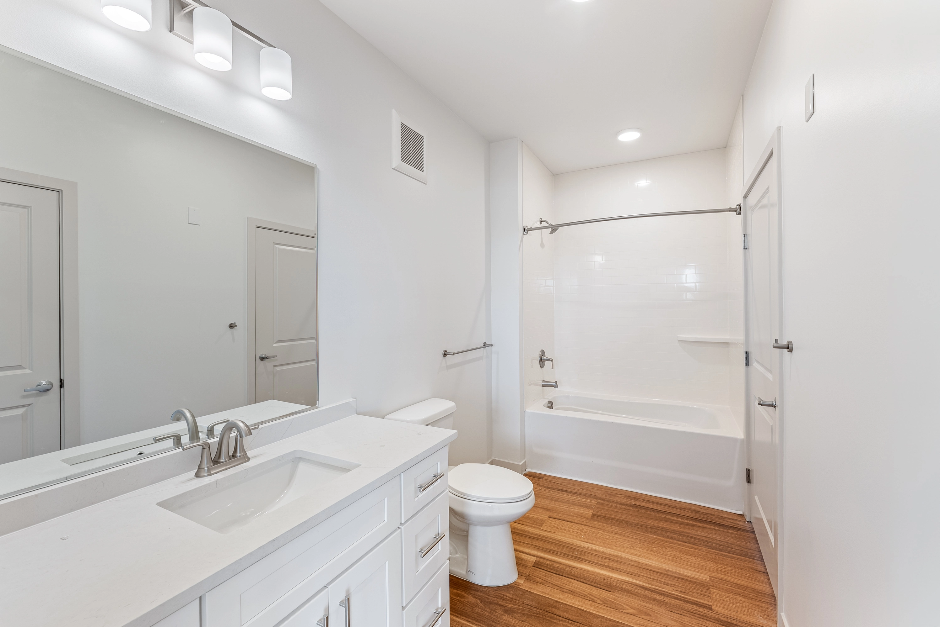 an image of a white bathroom with a toilet and bathtub