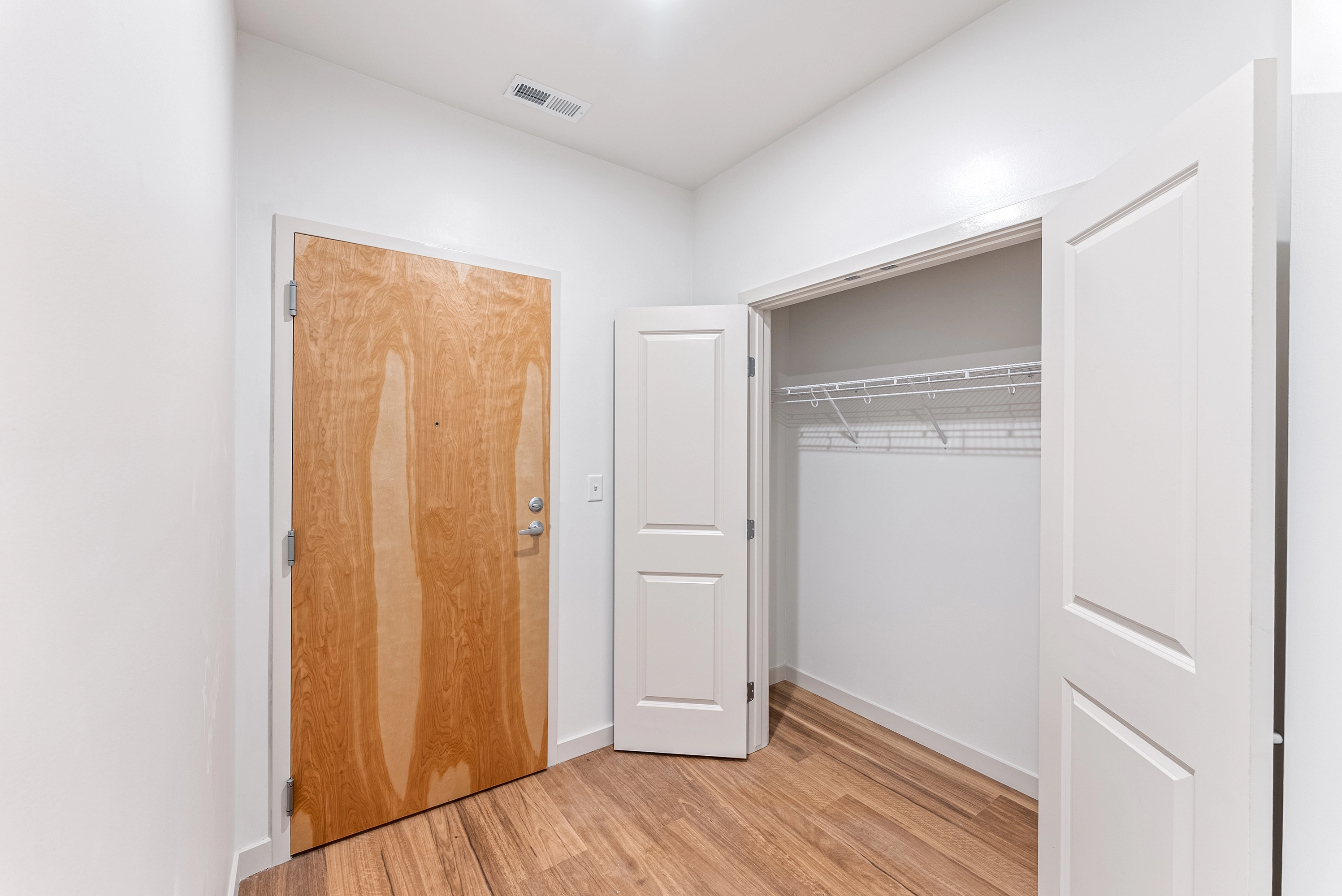 a room with a closed door and open closet doors