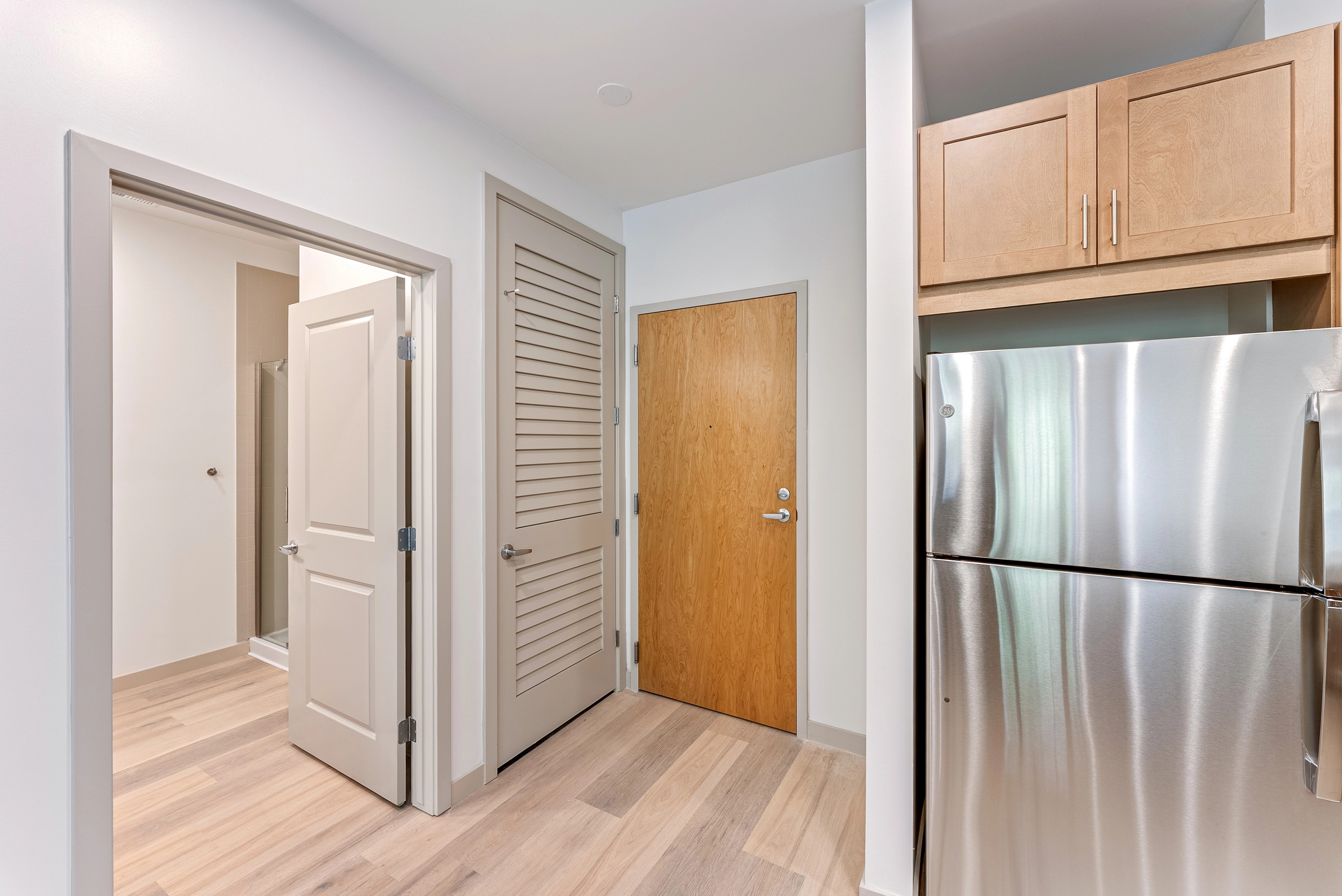 image of a front door with a fridge to the right of it