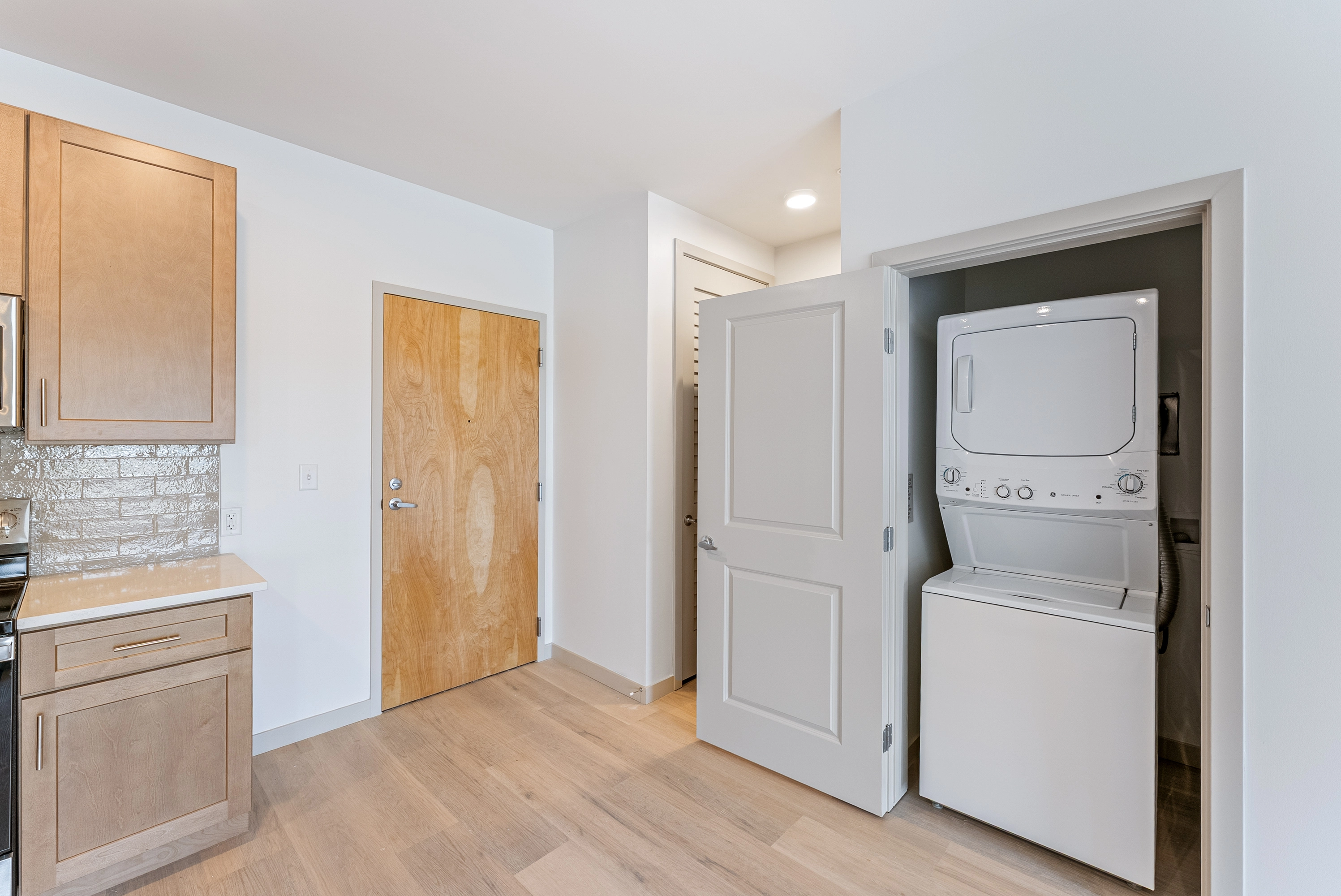 a open room with a stacked wash and dryer on the right side