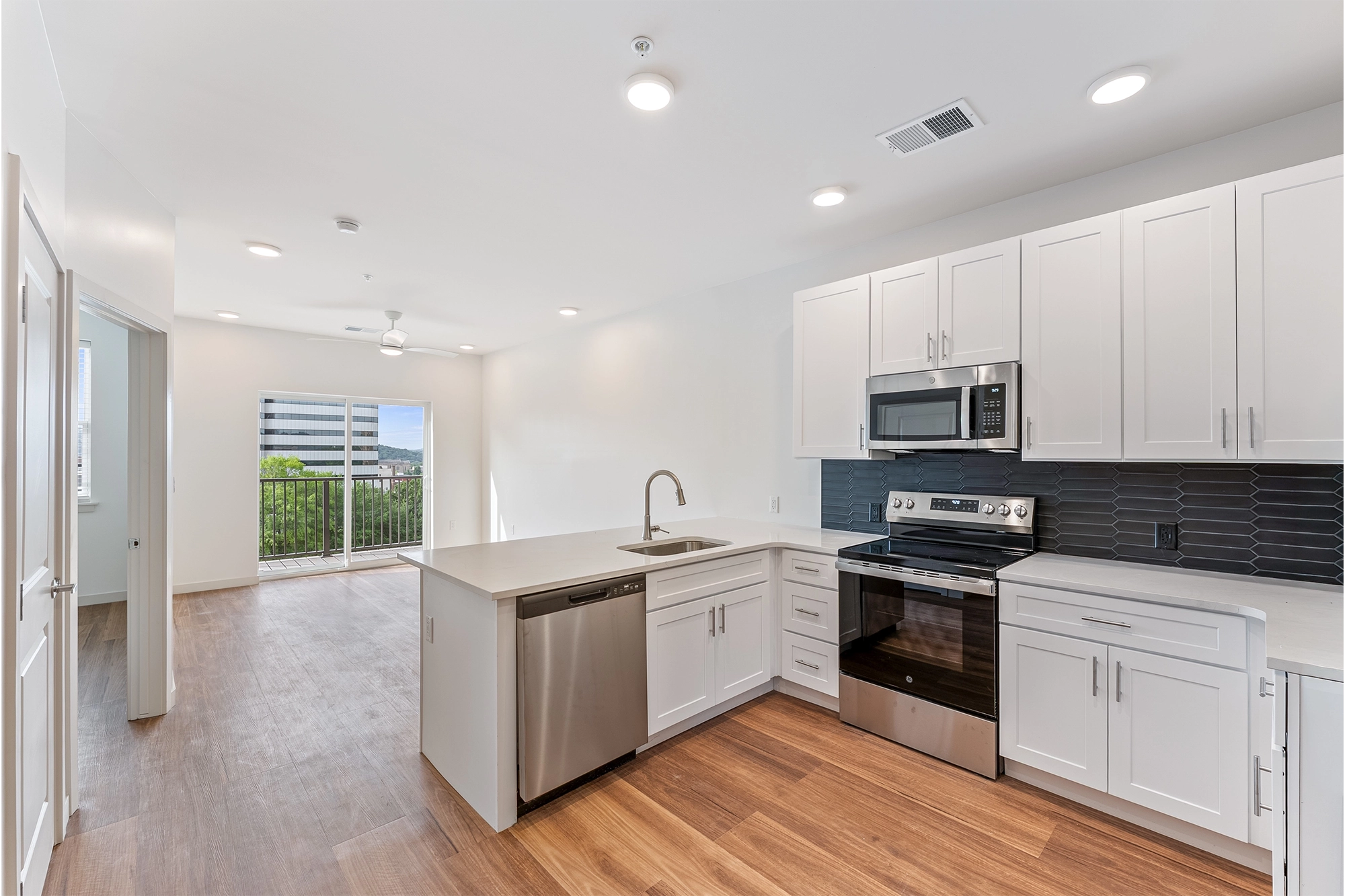 a modern kitchen with wooden flooring and stainless steel appliances
