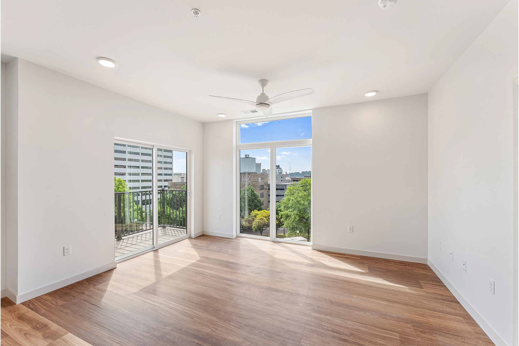 an open room with white walls and wooden flooring