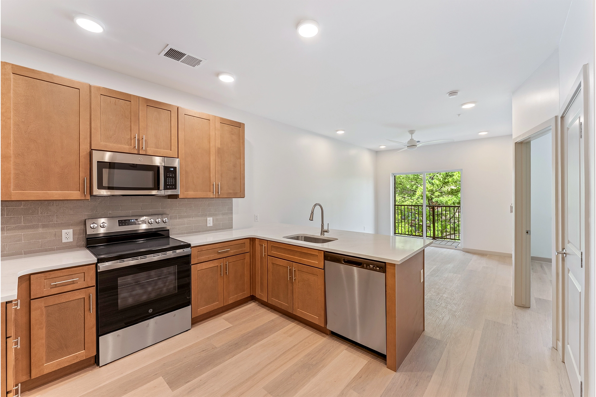 a modern kitchen with wooden flooring and stainless steel appliances