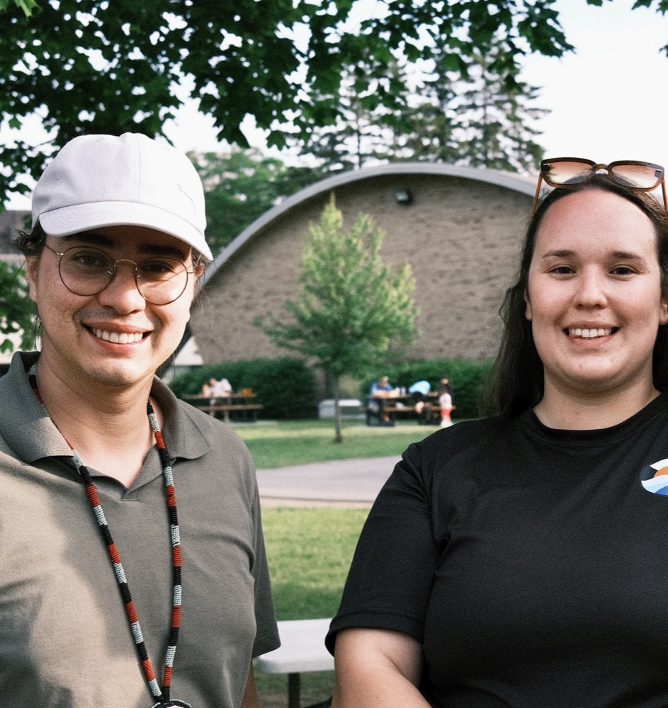 Deux membres du Comité jeunesse souriant lors d'un rassemblement extérieur