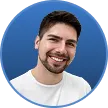 Smiling man with short brown hair and beard against a blue circular background.
