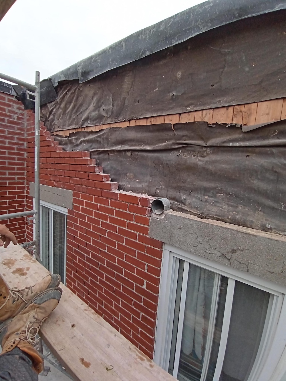 Severe brick facade deterioration and major masonry repair caused by moisture damage