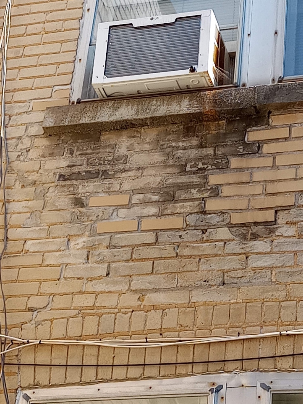 Close up of damaged brick surface with visible spalling and cracking