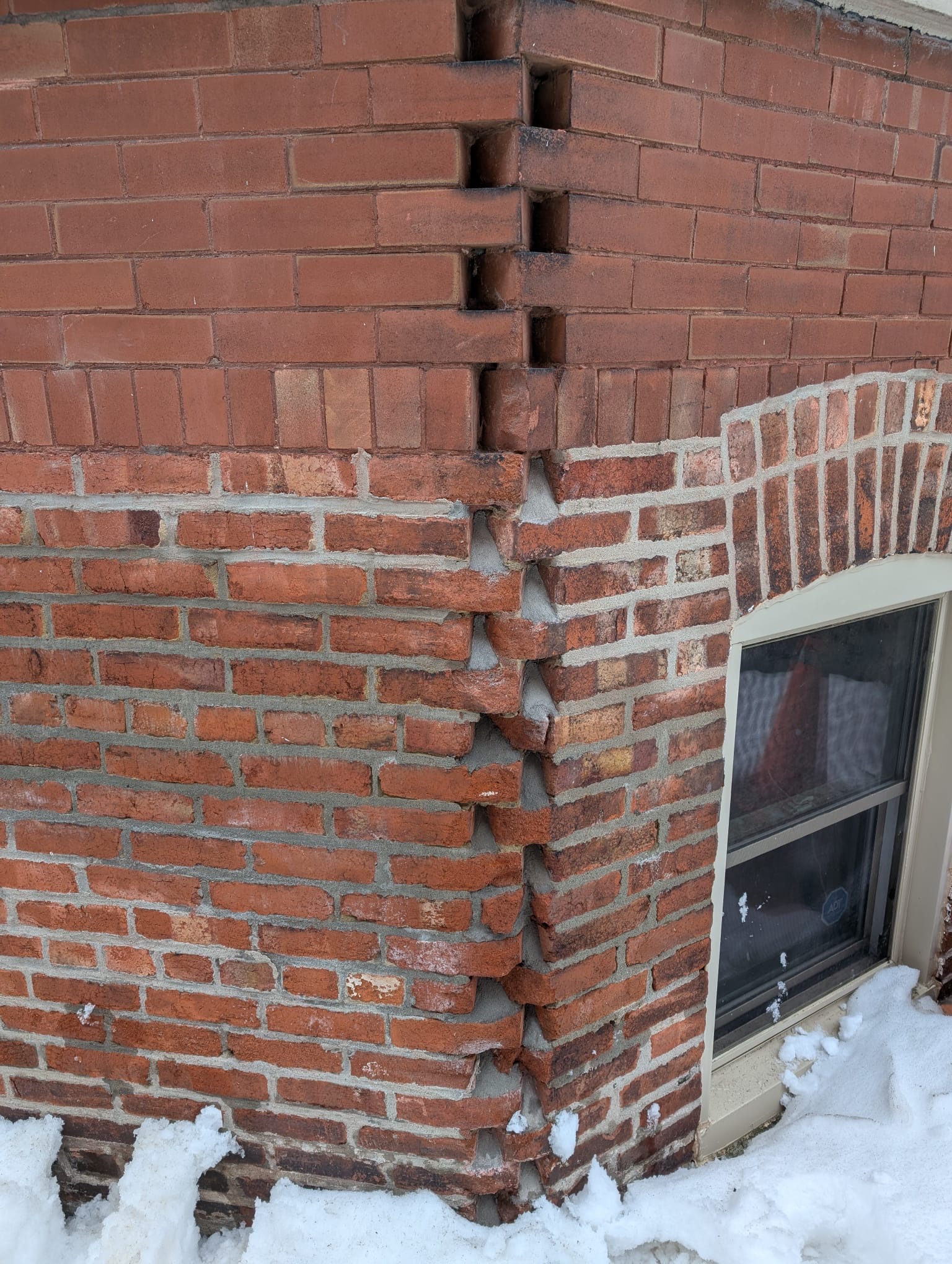Close up of cracked and deteriorating mortar joints on brick facade