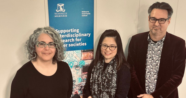 Three members of Seedkit team standing in front of vertical Melbourne Social Equity Institute banner