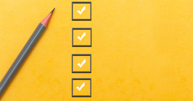 A grey pencil lying next to a column of four grey checkboxes with white ticks on a yellow background