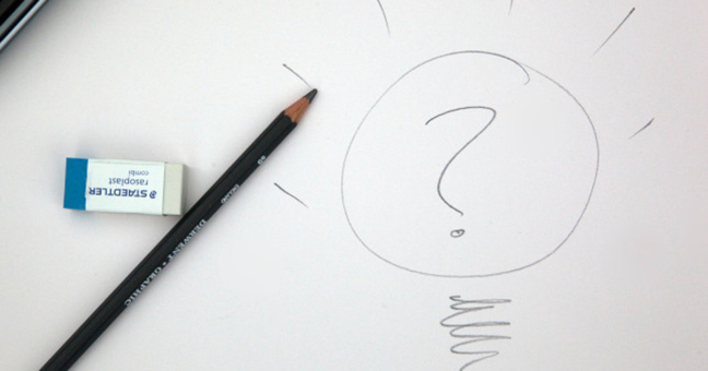 Pencil and eraser lying on a piece of paper with a sketch of a lightbulb on it