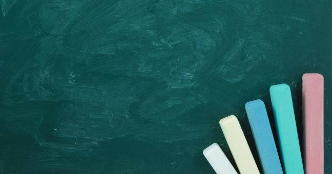 Chalkboard with five sticks of chalk 
